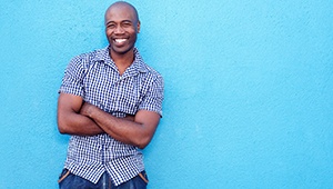 man smiling against light blue background