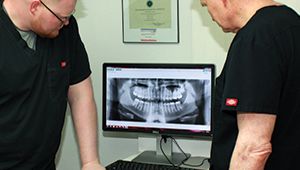 The doctors looking at dental x-rays on computer