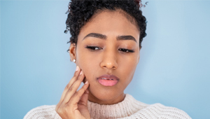 woman with tooth pain holding cheek