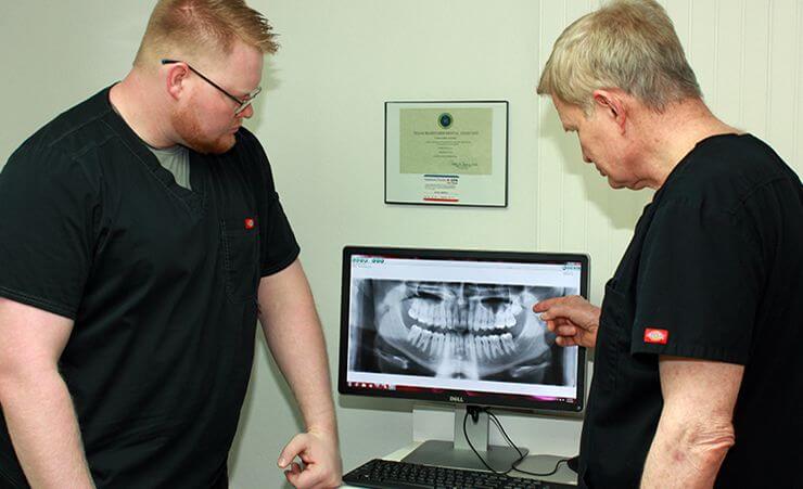Both Drs. Boyles looking at x-rays on computer
