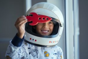 child smiling and dressed as an astronaut