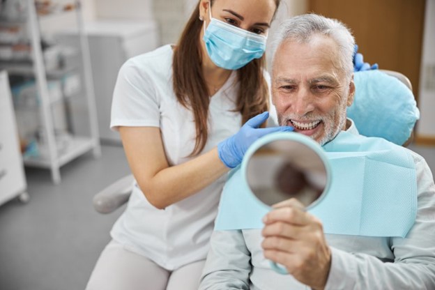 Older man at the dentist after receiving dental implants.